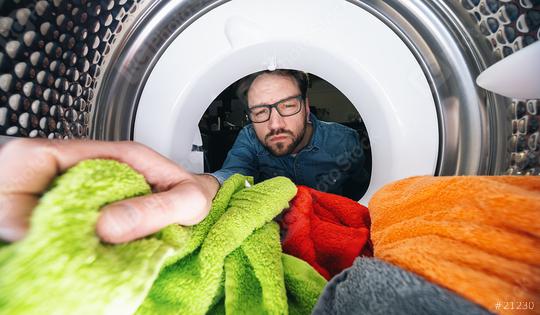 Man with glasses reaching Inside a washing machine or dryer doing laundry View from the inside  : Stock Photo or Stock Video Download rcfotostock photos, images and assets rcfotostock | RC Photo Stock.: