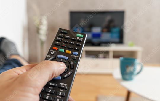 man with the remote control in hand watching the smart tv and presses the button on the remote control. Remote control in hand closeup.  : Stock Photo or Stock Video Download rcfotostock photos, images and assets rcfotostock | RC Photo Stock.: