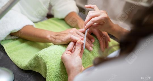 Manicurist applying treatment to client