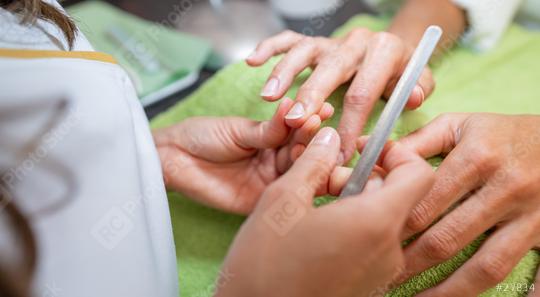 Manicurist applying treatment to client