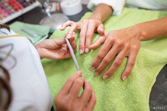 Manicurist applying treatment to woman