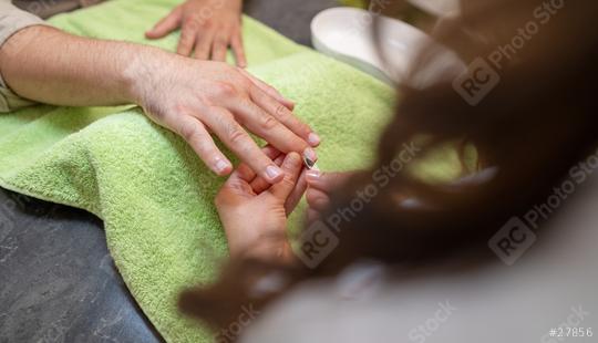 Manicurist performing a manicure, focusing on a client