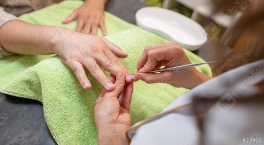 Manicurist performing a manicure, focusing on a client