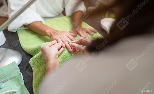 Manicurist trimming cuticles of a female client at a beauty salon with tools on table  : Stock Photo or Stock Video Download rcfotostock photos, images and assets rcfotostock | RC Photo Stock.: