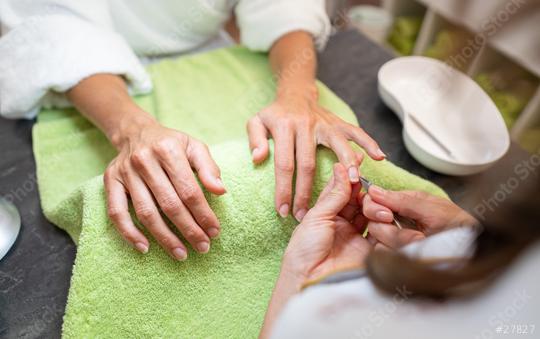 Manicurist trimming cuticles of a female client at a salon with tools on table in a beauty salon  : Stock Photo or Stock Video Download rcfotostock photos, images and assets rcfotostock | RC Photo Stock.: