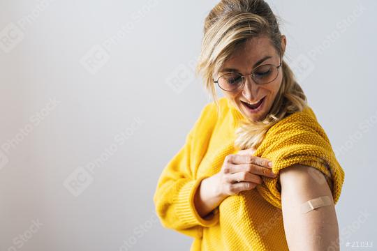 mature woman getting a vaccine injection for Covid-19. Woman holding up her shirt sleeve and showing her arm with Adhesive bandage Plaster after receiving vaccination  : Stock Photo or Stock Video Download rcfotostock photos, images and assets rcfotostock | RC Photo Stock.: