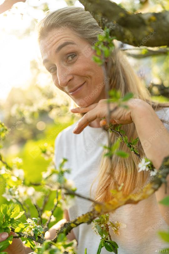 Mature woman smiling in an apple tree in blossom during spring  : Stock Photo or Stock Video Download rcfotostock photos, images and assets rcfotostock | RC Photo Stock.: