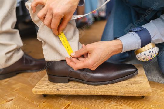 Measuring trouser length with tape on man