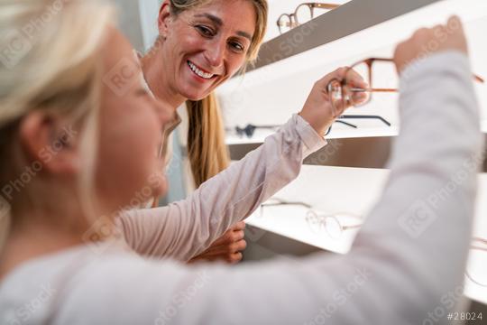 Mother and child looking at glasses in an optical store to buy some new glasses  : Stock Photo or Stock Video Download rcfotostock photos, images and assets rcfotostock | RC Photo Stock.: