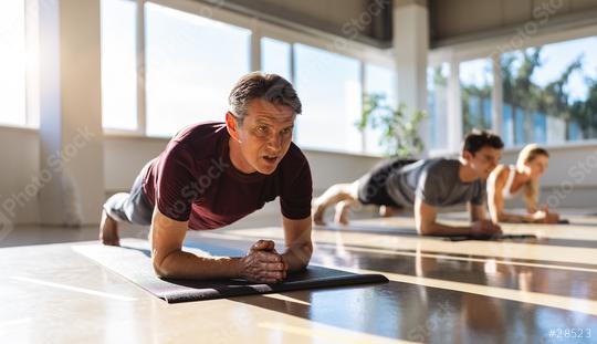 muscular man and woman doing planking exercises in gym on a yoga mat position on elbows while training in studio  : Stock Photo or Stock Video Download rcfotostock photos, images and assets rcfotostock | RC Photo Stock.: