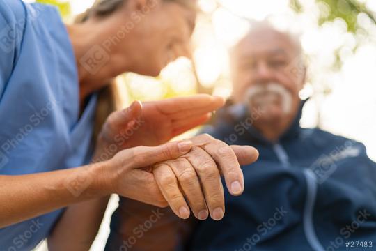 Nurse holding the hand of an elderly man in a wheelchair, both visible in soft focus with a sunlit background, offering comfort and support   : Stock Photo or Stock Video Download rcfotostock photos, images and assets rcfotostock | RC Photo Stock.: