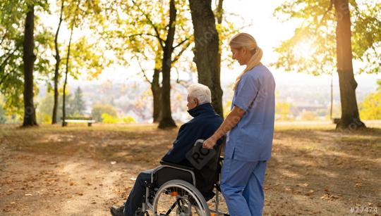 nurse walks with an elderly man in a wheelchair through a sunlit park, surrounded by autumn foliage. nursery home concept image  : Stock Photo or Stock Video Download rcfotostock photos, images and assets rcfotostock | RC Photo Stock.: