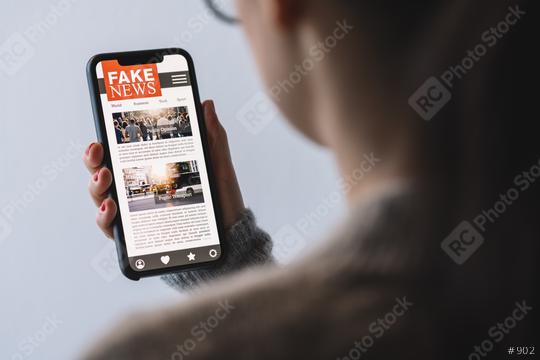 Online fake news on a mobile phone. Close up of woman reading Fake news HOAX or articles in a smartphone screen application. Hand holding smart device. Mockup website. Fake Newspaper portal.  : Stock Photo or Stock Video Download rcfotostock photos, images and assets rcfotostock | RC Photo Stock.: