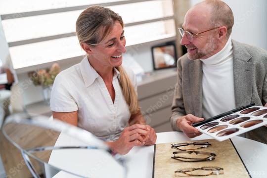 optician and customer smiling and looking at a selection of sunglasses lenses for eyeglasses in optical store.  : Stock Photo or Stock Video Download rcfotostock photos, images and assets rcfotostock | RC Photo Stock.: