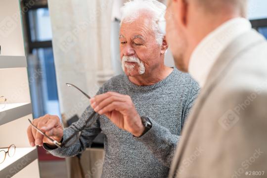 Optician conducts a consultation with a senior men examining eyeglasses in a optical store  : Stock Photo or Stock Video Download rcfotostock photos, images and assets rcfotostock | RC Photo Stock.: