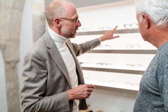 Optician pointing at different glasses on display to senior customer in shop  : Stock Photo or Stock Video Download rcfotostock photos, images and assets rcfotostock | RC Photo Stock.: