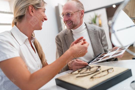 optician showing and smiling while looking at a selection of sunglasses lenses in optical store  : Stock Photo or Stock Video Download rcfotostock photos, images and assets rcfotostock | RC Photo Stock.: