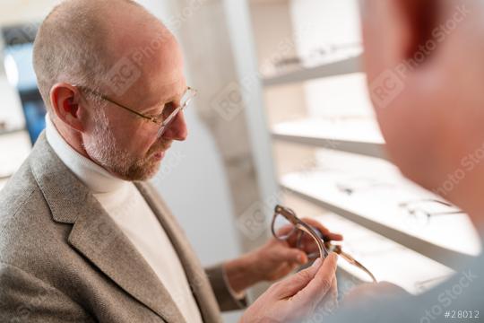 Optician showing eyeglasses to elderly client in optical store
.  : Stock Photo or Stock Video Download rcfotostock photos, images and assets rcfotostock | RC Photo Stock.: