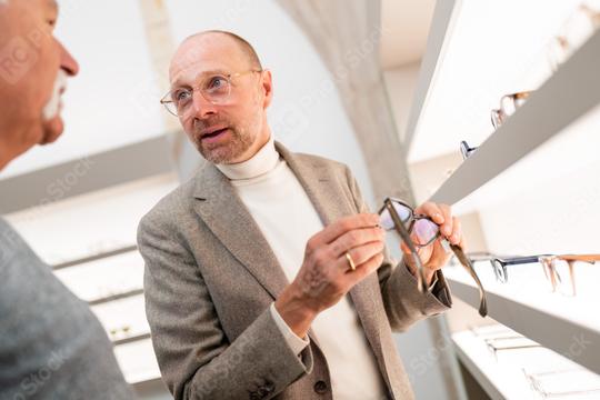 Optician speaking to senior customer for a new eyewear model in optical store. With  professional consultation and choosing spectacles  : Stock Photo or Stock Video Download rcfotostock photos, images and assets rcfotostock | RC Photo Stock.: