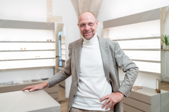 optician wearing glasses smiling in an eyewear shop. He is weari  : Stock Photo or Stock Video Download rcfotostock photos, images and assets rcfotostock | RC Photo Stock.: