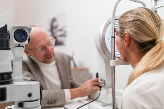 Optometrist adjusting keratograph for a eye examination in aclinic. Man and woman sitting at a table talking each other.  : Stock Photo or Stock Video Download rcfotostock photos, images and assets rcfotostock | RC Photo Stock.: