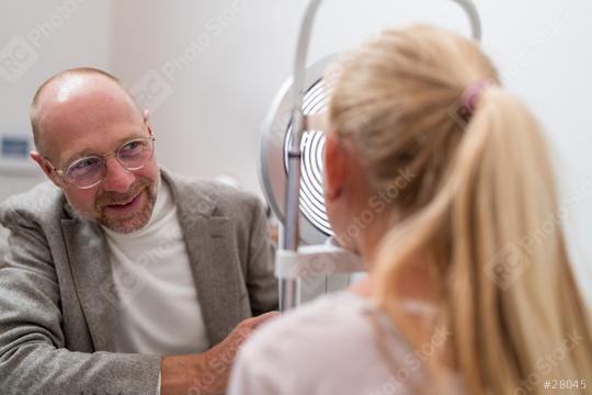 Optometrist during optical analysis with keratograph a child