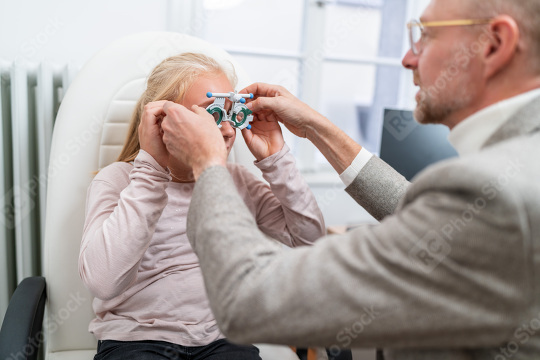 Optometrist fitting Optical measuring glasses on a young blonde   : Stock Photo or Stock Video Download rcfotostock photos, images and assets rcfotostock | RC Photo Stock.: