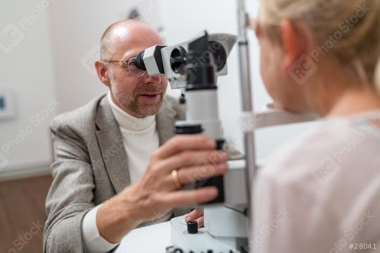 Optometrist using slit lamp machine to examine a child patient