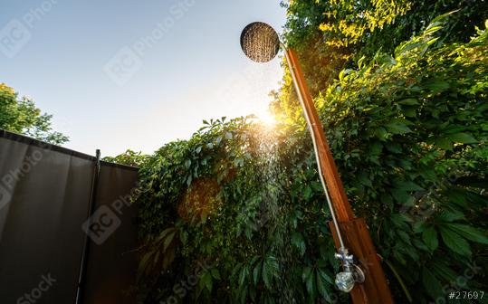 Outdoor shower sprinkler in the garden for swimming in the resort pool at sunset. Golden Hour Refreshment Spa wellness concept image  : Stock Photo or Stock Video Download rcfotostock photos, images and assets rcfotostock | RC Photo Stock.: