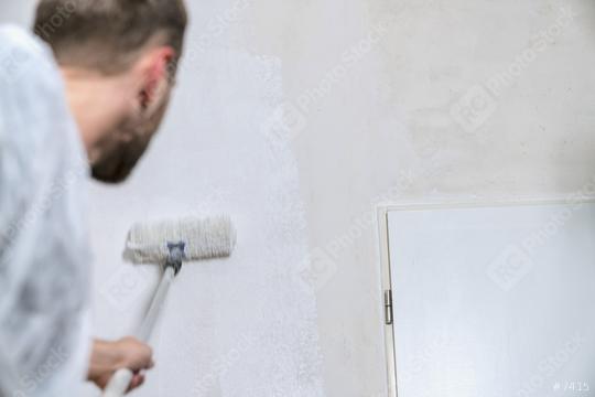 painter working with paint roller to paint the wall of a room with white color. do it yourself concept image  : Stock Photo or Stock Video Download rcfotostock photos, images and assets rcfotostock | RC Photo Stock.: