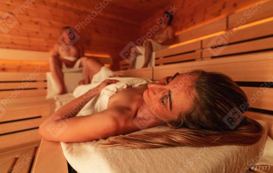 People relaxing in a wooden finnish sauna, warm light, focus on woman lying down  : Stock Photo or Stock Video Download rcfotostock photos, images and assets rcfotostock | RC Photo Stock.: