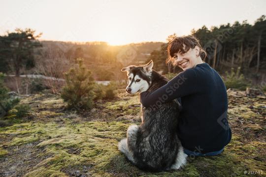Person and dog are having fun and looking at the camera. The woman and the husky enjoy the view in a beautiful landscape. Hugging at sunset.   : Stock Photo or Stock Video Download rcfotostock photos, images and assets rcfotostock | RC Photo Stock.: