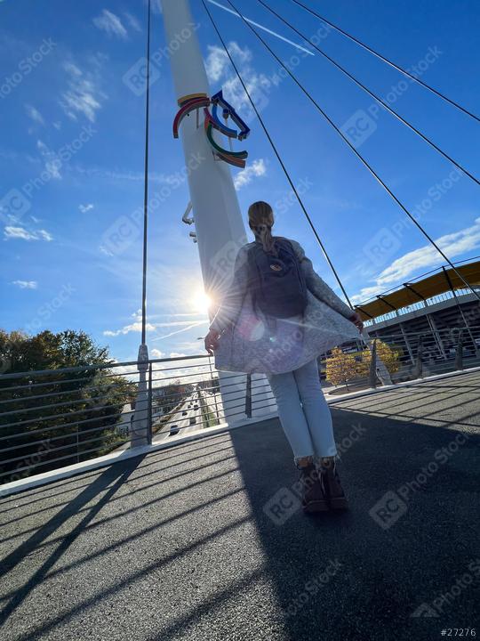 person in a gray cardigan and jeans stands on a bridge, looking up at a colorful horse emblem on a pole, with a blue sky and a modern bridge with chio sign in the background
  : Stock Photo or Stock Video Download rcfotostock photos, images and assets rcfotostock | RC Photo Stock.: