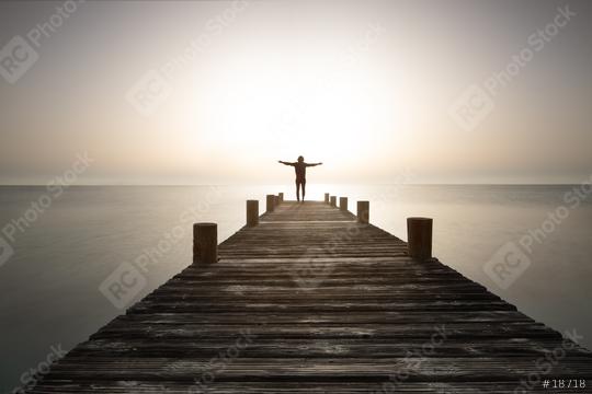 Person stands with open arms on the pier at sunrise. Powerful mediations, relaxation, recharge your batteries and enjoy life.  : Stock Photo or Stock Video Download rcfotostock photos, images and assets rcfotostock | RC Photo Stock.: