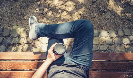Point of view shot of a man sits on a bench in the park and holding a take away coffee  : Stock Photo or Stock Video Download rcfotostock photos, images and assets rcfotostock | RC Photo Stock.: