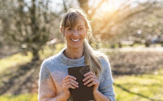 Portrait of a happy female student holding books and looking at camera outdoors  : Stock Photo or Stock Video Download rcfotostock photos, images and assets rcfotostock | RC Photo Stock.: