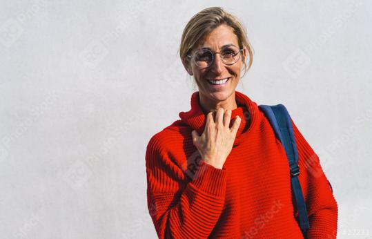 Portrait of a young woman with pleasant smile and glasses who grabs her red turtleneck isolated on a concrete wall with copy space. Beautiful student girl looking at camera University concept image.  : Stock Photo or Stock Video Download rcfotostock photos, images and assets rcfotostock | RC Photo Stock.: