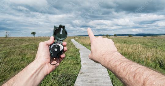 POV image of traveler man holding a compass and pointing direction in the landscape.  : Stock Photo or Stock Video Download rcfotostock photos, images and assets rcfotostock | RC Photo Stock.: