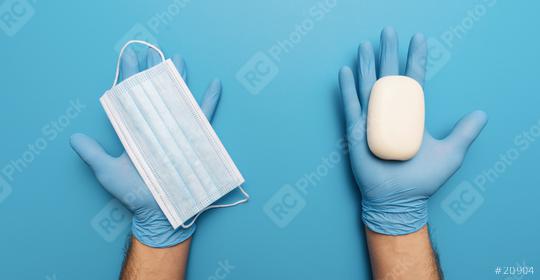 Products to stay safe during pandemic covid19 quarantine. Hands in blue gloves holding sanitiser gel, soap, medical face masks on blue abstract background. Protection against coronavirus, banner size  : Stock Photo or Stock Video Download rcfotostock photos, images and assets rcfotostock | RC Photo Stock.:
