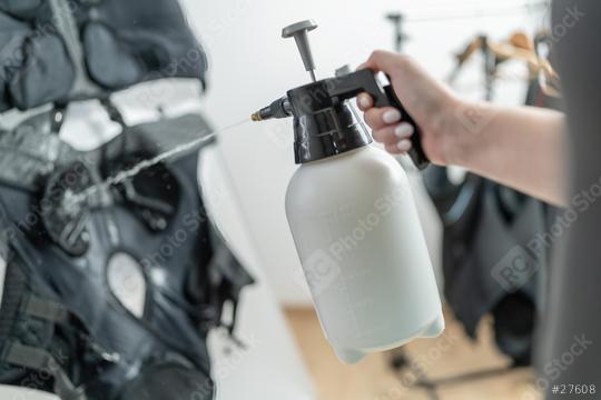 rainer use a spray bottle to preparing ems vest with water for training in a EMS Studio  : Stock Photo or Stock Video Download rcfotostock photos, images and assets rcfotostock | RC Photo Stock.: