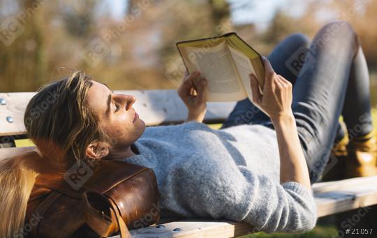Reading woman laying in the park on her bag at a bench.  student reading a book concept image  : Stock Photo or Stock Video Download rcfotostock photos, images and assets rcfotostock | RC Photo Stock.: