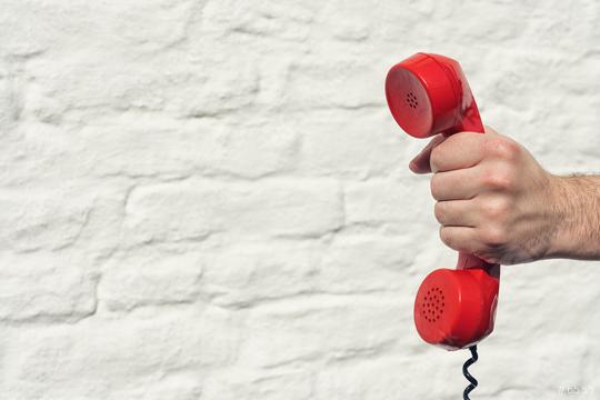 red handset in hand on a brick wall background  : Stock Photo or Stock Video Download rcfotostock photos, images and assets rcfotostock | RC Photo Stock.: