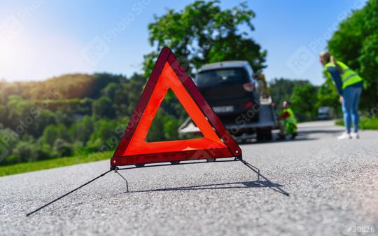 Red warning triangle on road with woman and tow truck in background checking his signaling car having trouble in a rural area  : Stock Photo or Stock Video Download rcfotostock photos, images and assets rcfotostock | RC Photo Stock.: