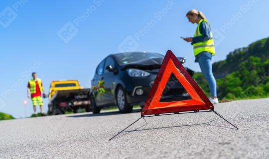 Red warning triangle on road with woman using smartphone and Roadside assistance worker on a tow truck in background. Roadside assistance concept image.  : Stock Photo or Stock Video Download rcfotostock photos, images and assets rcfotostock | RC Photo Stock.: