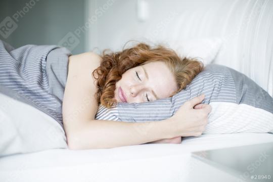 Red-haired woman peacefully sleeping on a striped pillow in a bright bedroom, wrapped in cozy gray bedding, conveying rest, relaxation, and a calm, serene morning atmosphere  : Stock Photo or Stock Video Download rcfotostock photos, images and assets rcfotostock | RC Photo Stock.: