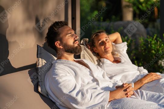 Relaxed couple in white robes lounging outdoors in the sunlight  : Stock Photo or Stock Video Download rcfotostock photos, images and assets rcfotostock | RC Photo Stock.: