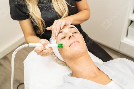 relaxed woman lying on the medical bed with her eyes closed while having aquafacial clean procedure at a cosmetology salon.  : Stock Photo or Stock Video Download rcfotostock photos, images and assets rcfotostock | RC Photo Stock.: