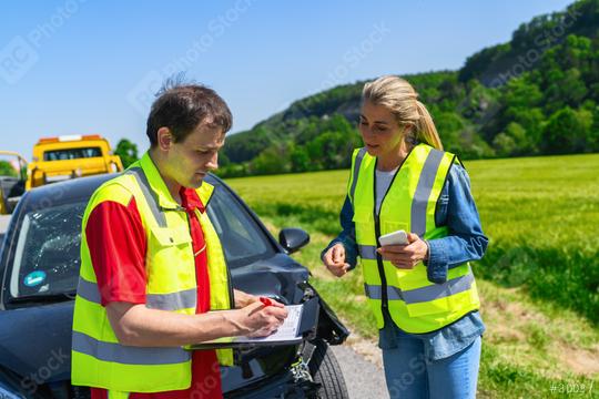 Roadside assistance worker filling out paperwork with customer against backdrop of tow truck and damaged car  : Stock Photo or Stock Video Download rcfotostock photos, images and assets rcfotostock | RC Photo Stock.: