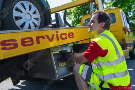 Roadside service professional worker operating machinery lift with a car on a tow truck with the word service  : Stock Photo or Stock Video Download rcfotostock photos, images and assets rcfotostock | RC Photo Stock.: