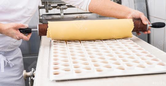 Rolling out cookie dough over a cookie cutter mold to shape cookies, using a wooden rolling pin, in a bakery setting  : Stock Photo or Stock Video Download rcfotostock photos, images and assets rcfotostock | RC Photo Stock.: